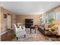Comfortable living room featuring hardwood floors, a large television, and stylish furniture at 2085 E 127Th Pl, Thornton, CO 80241