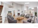 Bright, open living area featuring a fireplace, vaulted ceiling, and large windows for ample natural light at 2330 Redwood Ave, Lafayette, CO 80026