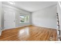 An empty room with wood floors, white door and trim, and a bright window at 2926 Castle Peak Ave, Superior, CO 80027