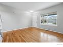 An empty room with wood floors, white door and trim, and a bright window at 2926 Castle Peak Ave, Superior, CO 80027