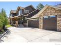 Charming home featuring a spacious concrete driveway leading to a three-car garage with stone accents at 313 S 3Rd Ave, Superior, CO 80027