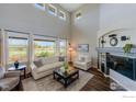Bright living room with high ceilings, large windows, fireplace and hardwood floors at 4203 Rabbit Mountain Rd, Broomfield, CO 80020