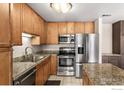 Well-lit kitchen featuring stainless steel appliances, granite counters, and natural wood cabinets at 4500 Baseline Rd # 3302, Boulder, CO 80303