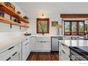Bright kitchen featuring white countertops, shaker cabinets, open shelves, and farmhouse sink offering a blend of style and functionality at 4731 Jay Rd, Boulder, CO 80301