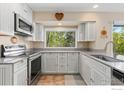 Charming kitchen features white cabinetry, granite countertops, and stainless steel appliances at 5587 Glendale Gulch Cir, Boulder, CO 80301