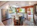 Bright kitchen featuring an island with seating, stainless steel appliances, and unique backsplash and wood paneling at 560 Iris Ave, Boulder, CO 80304