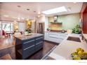 Open kitchen layout with large island, stainless steel appliances, and direct access to a dining area at 560 Iris Ave, Boulder, CO 80304