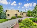Modern dome-shaped home with a gravel driveway, landscaped with green bushes and red roses at 6611 Lakeview Dr, Boulder, CO 80303