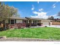 Charming ranch-style home featuring a well-manicured lawn, brick accents, and an attached two-car garage on a sunny day at 7960 Estes Ct, Arvada, CO 80005