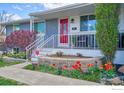 Inviting front porch with colorful tulip beds and updated front door offers charming curb appeal to this home at 8200 Delaware St, Denver, CO 80221