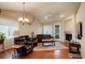 Bright living room featuring a fireplace, hardwood floors, leather furniture, and large windows at 8255 E 150Th Pl, Thornton, CO 80602