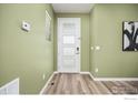 Clean entryway with wood floors and a modern door at 10022 Reunion Pkwy, Commerce City, CO 80022