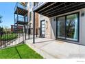 Private patio area with modern townhome showcasing stone accents and black metal balcony at 1385 N King St, Denver, CO 80204
