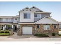 Charming townhome exterior with stone accents, a garage, and well-maintained landscaping at 14000 Winding River Ct # T3, Broomfield, CO 80023