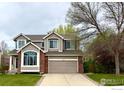 Traditional two-story home with a two-car garage and landscaped front yard at 1611 Red Mountain Dr, Longmont, CO 80504