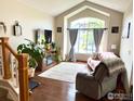 Bright living room with hardwood floors, large arched window and comfortable seating at 1611 Red Mountain Dr, Longmont, CO 80504