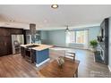 Modern kitchen with stainless steel appliances, center island, and sleek cabinetry open to the living area at 16807 E Napa Dr, Aurora, CO 80013