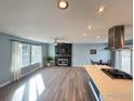 Open-concept living area featuring a modern fireplace, wood floors, and large bright windows at 16807 E Napa Dr, Aurora, CO 80013