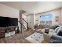 Inviting living room with a cozy sectional sofa, staircase, and abundant natural light at 192 Ambrose St, Erie, CO 80516