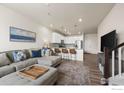 Open-concept living room connected to a modern kitchen with bar stool seating at 192 Ambrose St, Erie, CO 80516