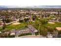 Expansive aerial view showcasing a residential neighborhood with mature trees, open green spaces and nearby mountain views at 1937 Meadow Dr # A7, Longmont, CO 80501