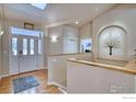 Inviting entryway with wood floors, a skylight, and decorative alcove with tree art at 2050 Emerald Dr, Longmont, CO 80504