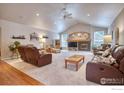 Spacious living room with vaulted ceiling, fireplace, and comfortable leather seating at 2050 Emerald Dr, Longmont, CO 80504