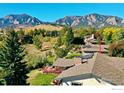 Scenic aerial view showcasing a home with a deck nestled amongst lush greenery and mountain views at 2490 Vassar Dr, Boulder, CO 80305