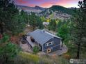 Secluded gray home with spacious deck surrounded by lush trees and mountain views at 2700 Crestridge Ct, Boulder, CO 80302