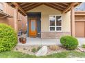 Close up of inviting front porch with stone accents, a wooden door, and decorative landscaping at 3714 Ridgeway St, Boulder, CO 80301