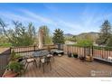 Relaxing outdoor deck featuring a table, chairs and mature trees with views of the mountains at 500 Mohawk Dr # 207, Boulder, CO 80303