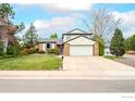 Classic two-story home with a brick facade, green lawn, and attached two-car garage at 5151 S Quintero St, Centennial, CO 80015