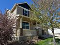 Charming home exterior with stone accents and inviting front porch, professionally designed landscape at 5478 Teton Dr, Longmont, CO 80504