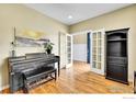 Cozy living room with hardwood floors, piano, and decorative shelves, perfect for entertaining at 5478 Teton Dr, Longmont, CO 80504