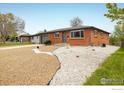 Charming single-story brick home with a gray roof and low-maintenance gravel landscaping at 740 Lotus Way, Broomfield, CO 80020