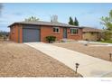 Charming single-story brick home with a gray roof and low-maintenance gravel landscaping at 740 Lotus Way, Broomfield, CO 80020