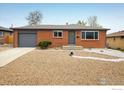 Charming single-story brick home with a gray roof and low-maintenance gravel landscaping at 740 Lotus Way, Broomfield, CO 80020