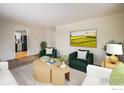 Open living space with seating area, natural light, and hardwood floors leading to the kitchen at 740 Lotus Way, Broomfield, CO 80020