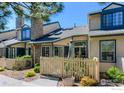 Townhouse showcasing a stone chimney, skylights, and a charming fenced front yard, offering privacy and curb appeal at 8750 Allison Dr # B, Westminster, CO 80005