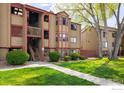 Inviting two-story exterior of a condo building featuring mature landscaping and well-maintained walkway at 8770 Corona St # 101, Denver, CO 80229