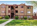 Inviting two-story exterior of a condo building featuring mature landscaping and well-maintained walkway at 8770 Corona St # 101, Denver, CO 80229