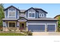 Charming two-story blue home with a well-manicured lawn and a two car garage in a great neighborhood at 910 Pope Dr, Erie, CO 80516