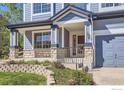 Inviting front porch with stone accents and railing, leading to a charming entryway at 910 Pope Dr, Erie, CO 80516