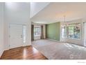 Bright living room with large windows, carpet flooring, and a chandelier at 910 Pope Dr, Erie, CO 80516