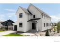 Stunning modern farmhouse exterior with white siding, black trim, and a well-maintained yard at 914 Eldorado Ln, Louisville, CO 80027