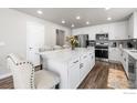 Bright kitchen with white cabinets, quartz countertops, stainless steel appliances, and spacious island seating at 922 Colorado River Ave, Brighton, CO 80601