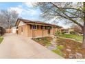 Well-maintained brick home with a manicured lawn, long driveway, and detached garage at 9261 Julian Way, Westminster, CO 80031