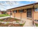 Inviting front porch with brick exterior and charming details and manicured garden beds at 9261 Julian Way, Westminster, CO 80031