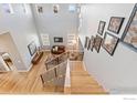 View from staircase of living room with hardwood floors, high ceilings, and large windows at 955 Horizon Ct, Erie, CO 80516