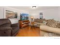 Comfortable living room features wood flooring, modern entertainment system, and neutral-toned furnishings at 109 S Fulton Ave, Fort Lupton, CO 80621